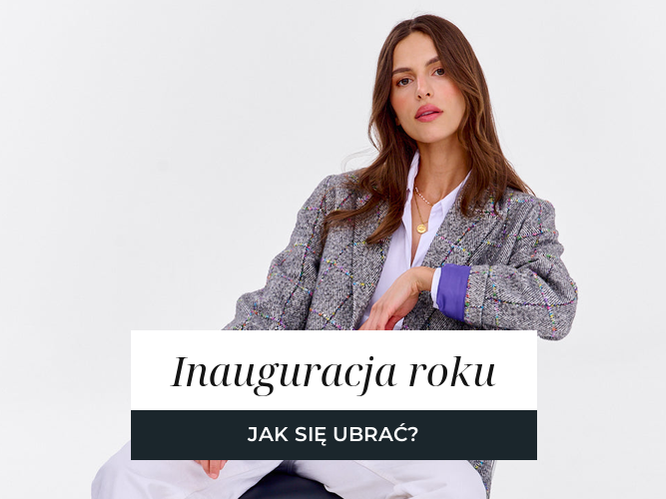 Kobieta w marynarce z wełny w szarą jodełkę, zestawionej z białą koszulą.